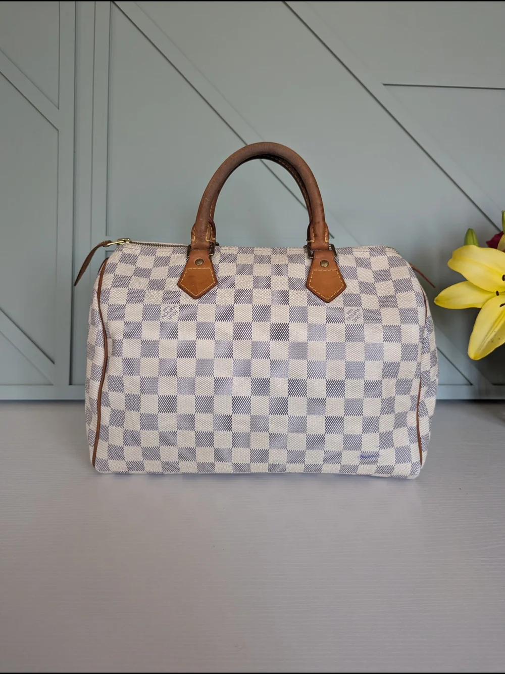 Louis Vuitton Speedyhandbag styled in the iconic Damier Azur canvas pattern.